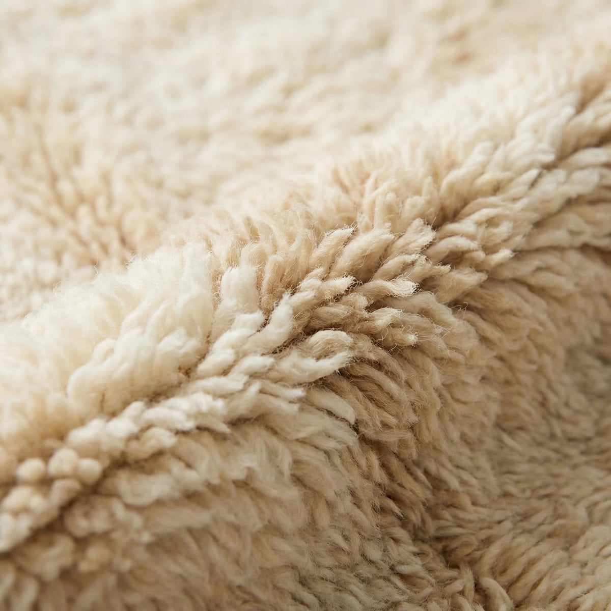 Detail of Moroccan wool rug, short dark blue lines near one end of a cream high-pile ground