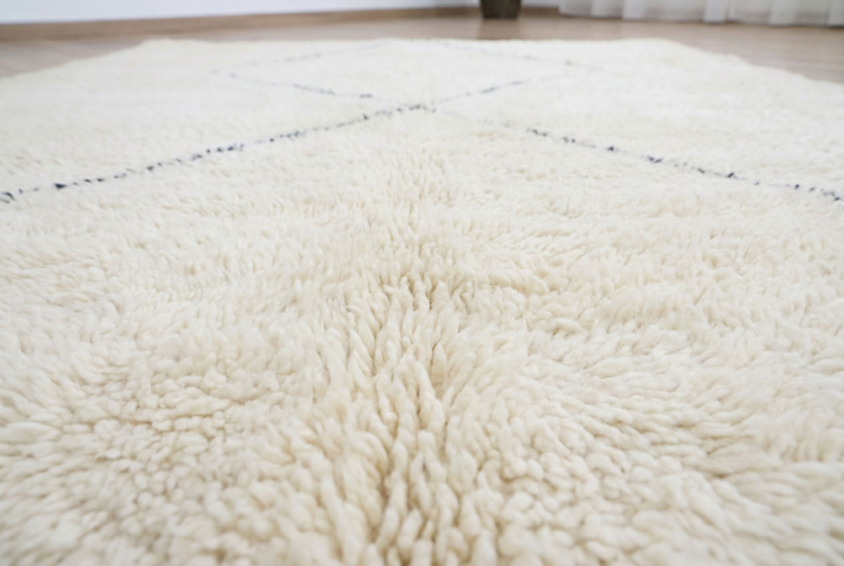 Detail of Beni Ourain wool rug, large open diamond shapes on a cream wool ground