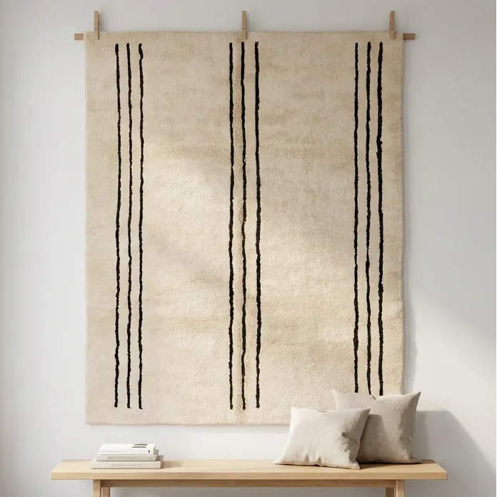Front view of Beni Ourain wool rug, groups of three bold black vertical lines on natural white wool