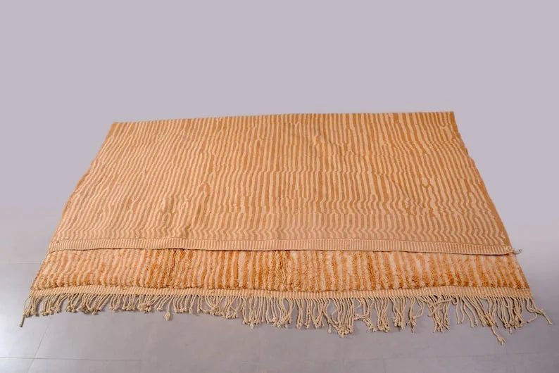Detail of Moroccan wool rug, warm sand beige ground with a tonal color texture