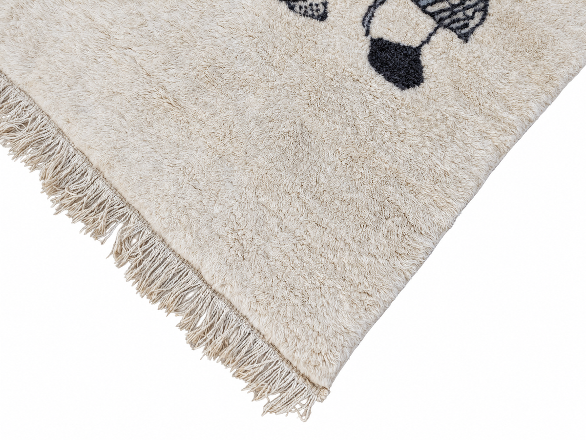 Detail of Cream Moroccan Wool Rug with Musician Motif, 305 × 198 cm.