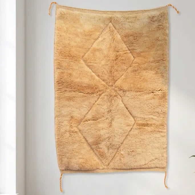 Beni Ourain wool rug, two subtly raised diamonds on a honey-colored wool ground in a bedroom setting